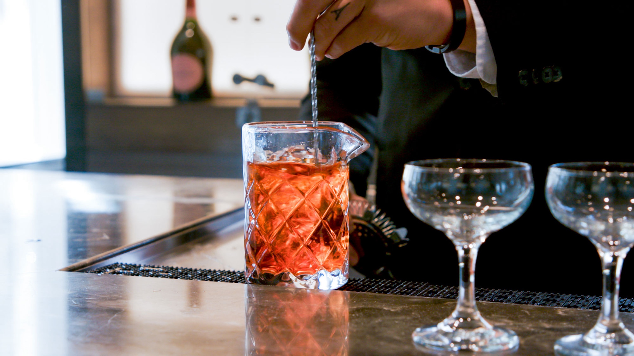 A bartender stirring liquor in a elegant glass at Bar Edera from Hotel Ivy