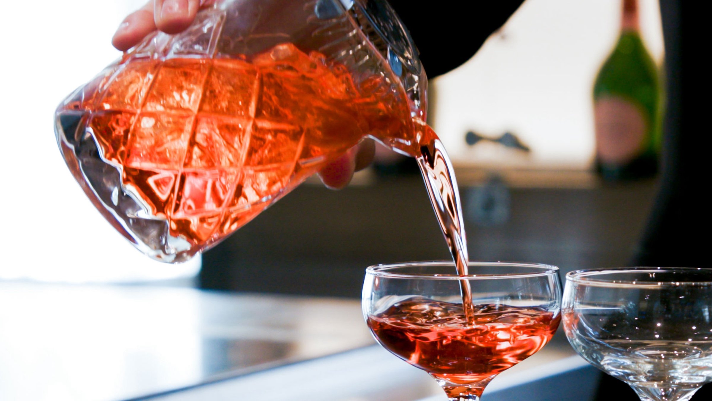 Pouring peach colour of liquor to transparent glass at Bar Edera from Hotel Ivy