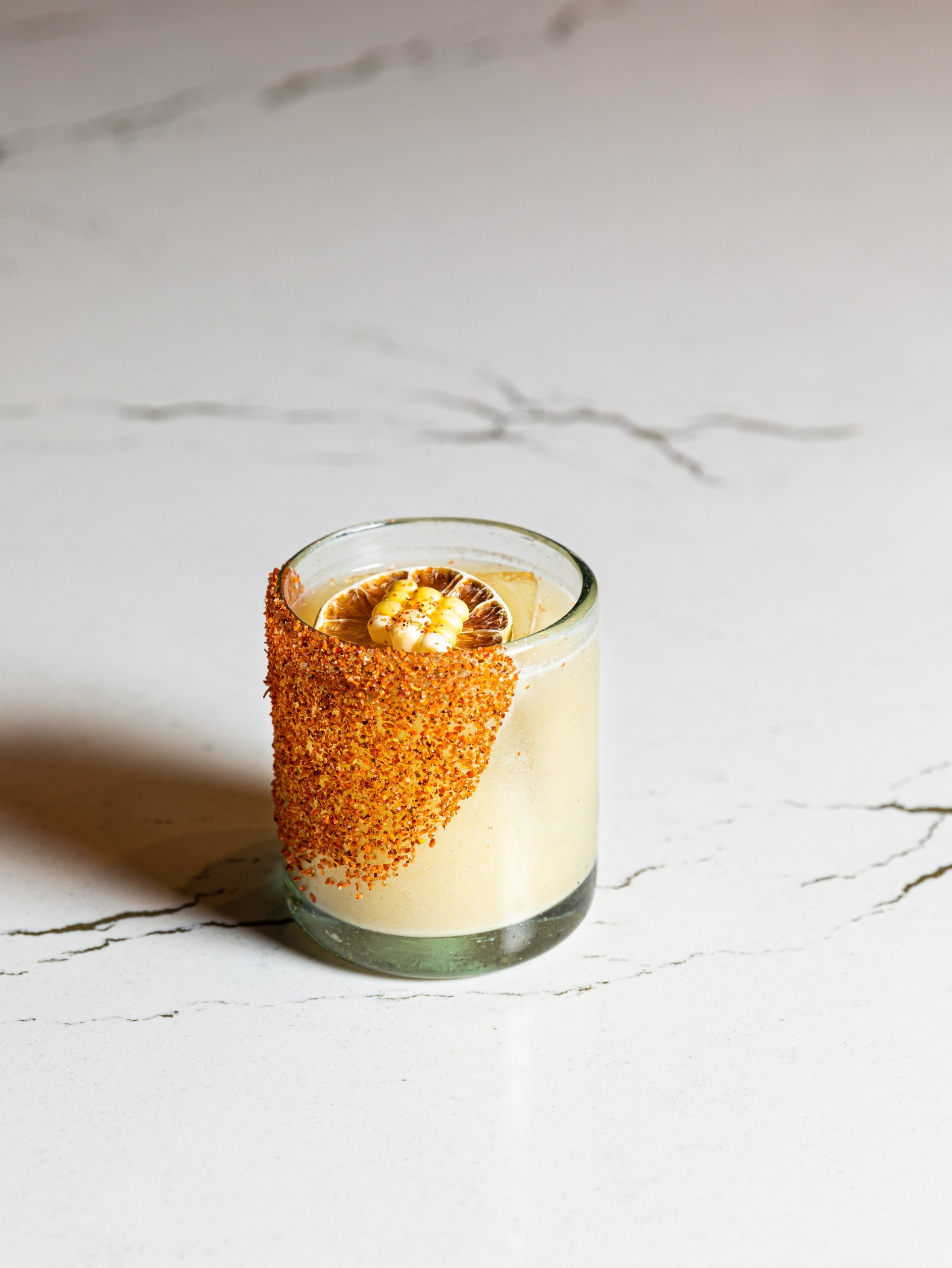 Light ivory coloured margarita with dried fruit and corn on a white marble table at Masa & Agave of Hotel Ivy