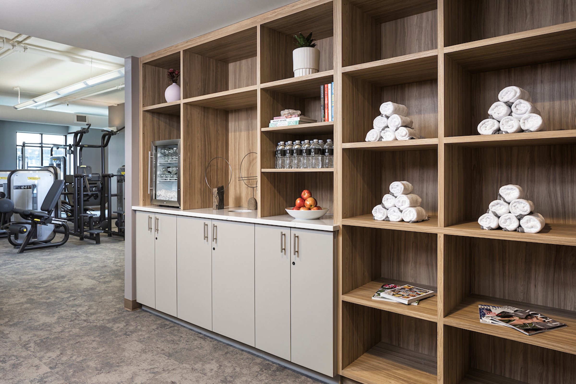 A large shelf with towers, water bottles, books, etc. at Anda Fitness of Hotel Ivy