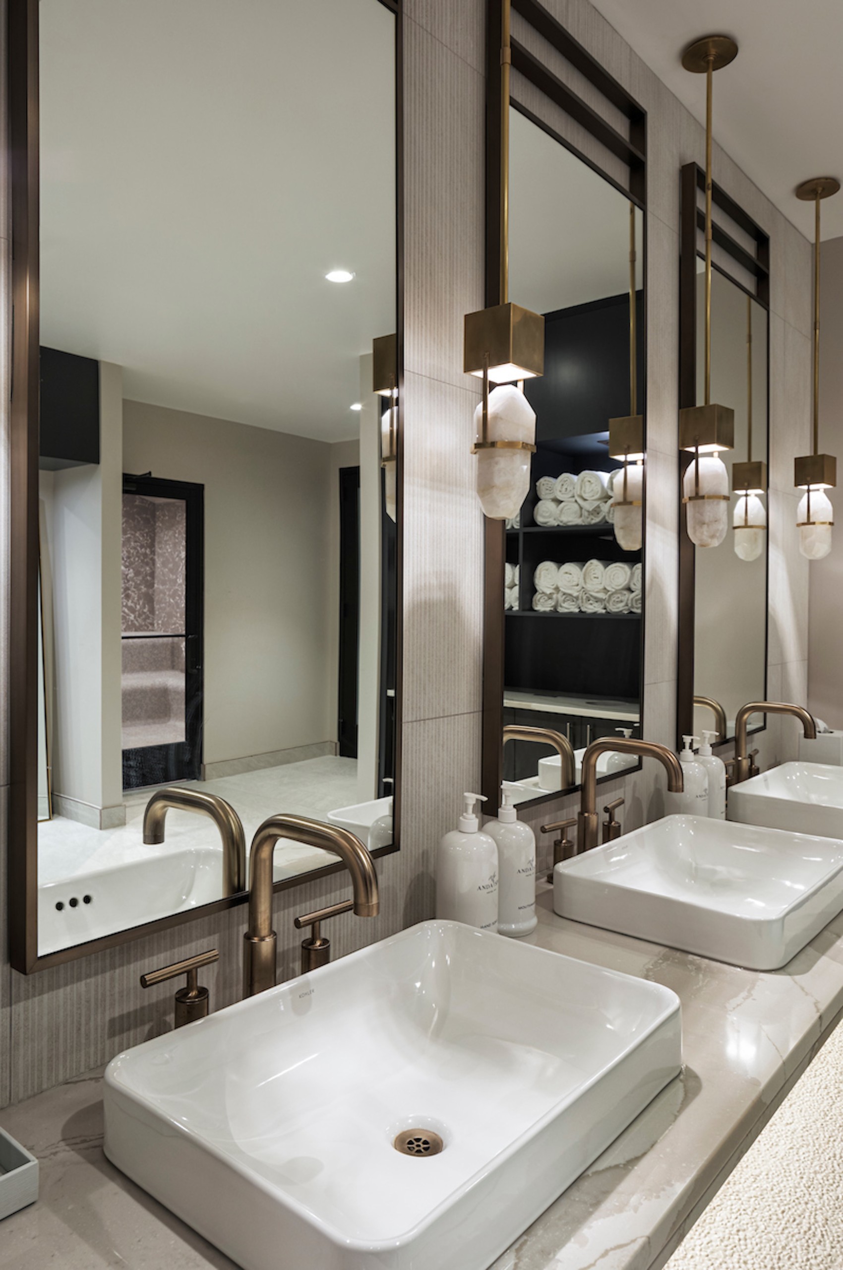 Sinks with amenities and mirrors reflecting towels from shelves at Anda Spa, Hotel Ivy