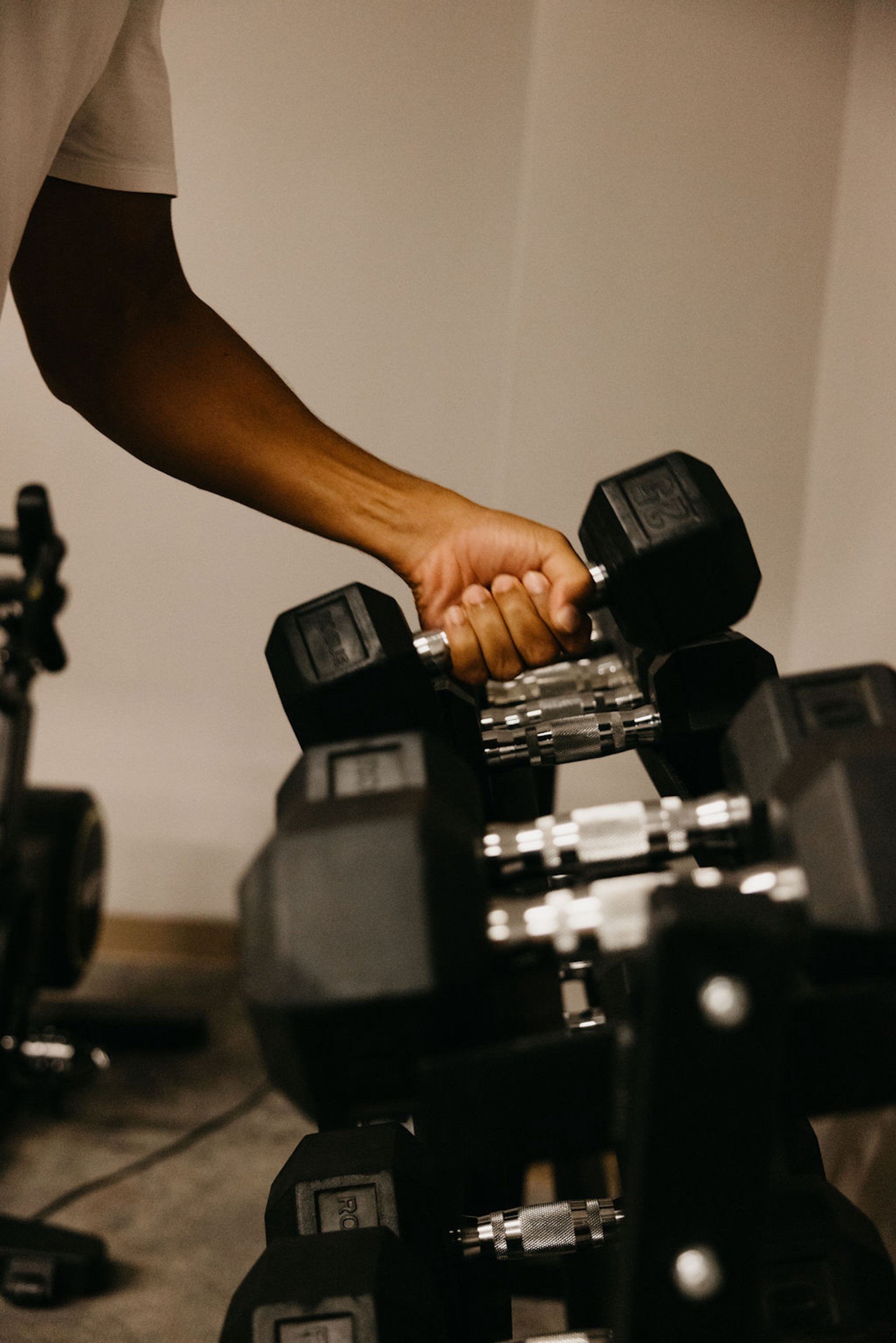 A man grabbing a dumbbell from Anda Fitness at Hotel Ivy