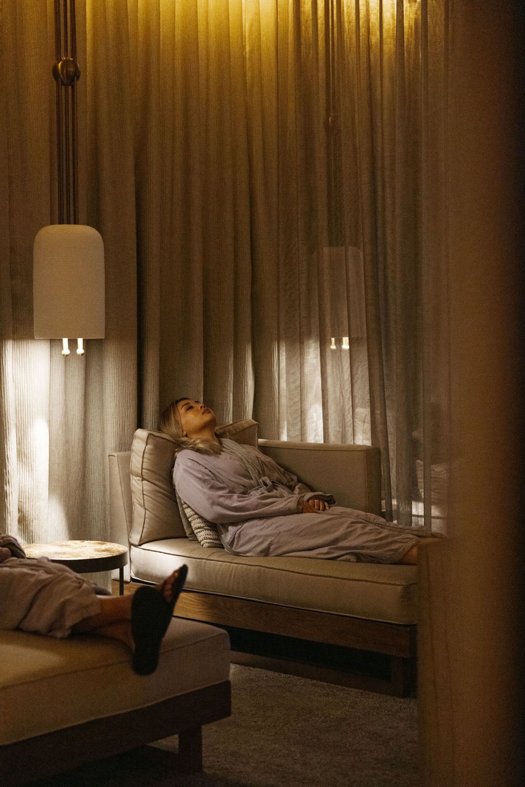 A woman sleeping on a comfortable spa couch in a relaxing lounge area